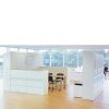 White storage units around a table with black chairs