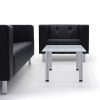 Black leather sofa and armchair, and glass topped coffee table